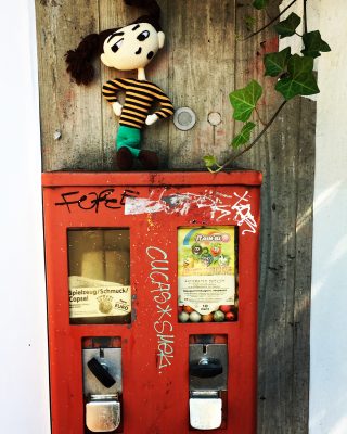 Marie sitzt auf einem alten, verlotterten Kaugummiautomaten – schwäbische Kurzgeschichte