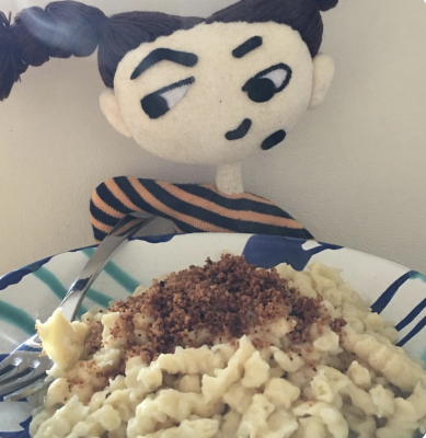 Marie sitzt vor einem Teller dampfender Spätzle mit gerösteten Semmelbröseln – schwäbische Kurzgeschichte